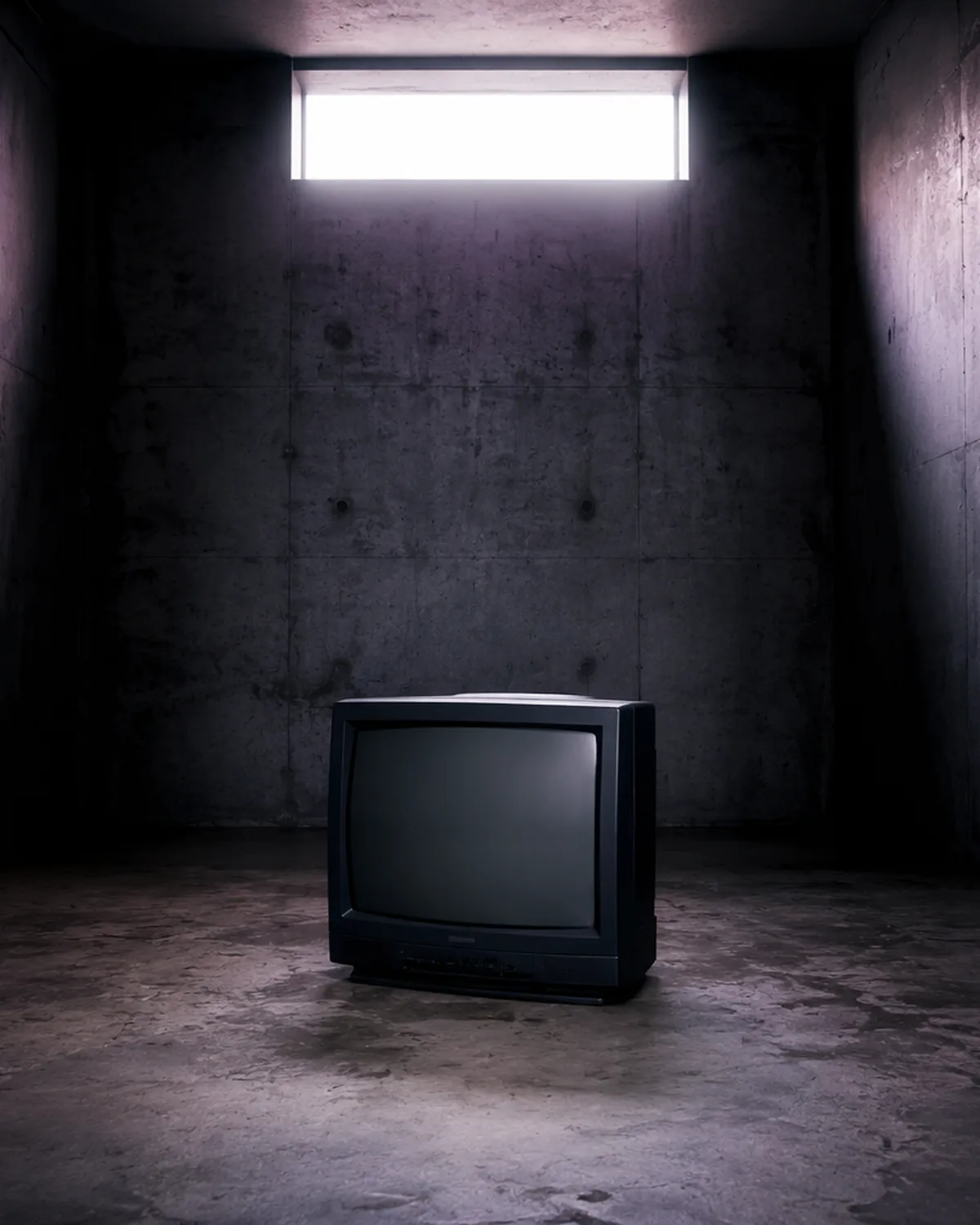Stará televize v tlumeně osvětleném betonovém prostoru, ilustrační obrázek k článku